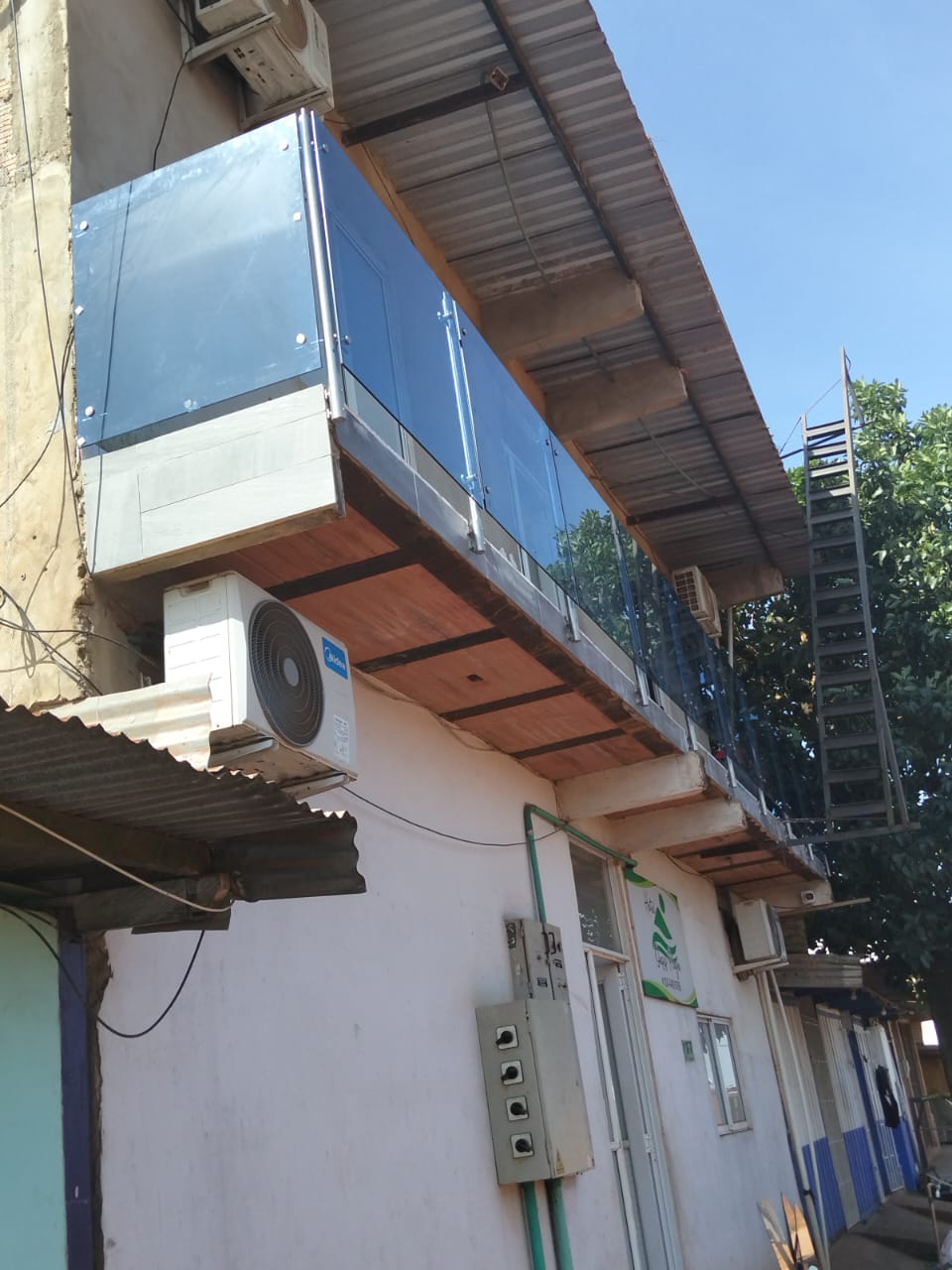 Balcón en vidrio azul con herrajes en acero